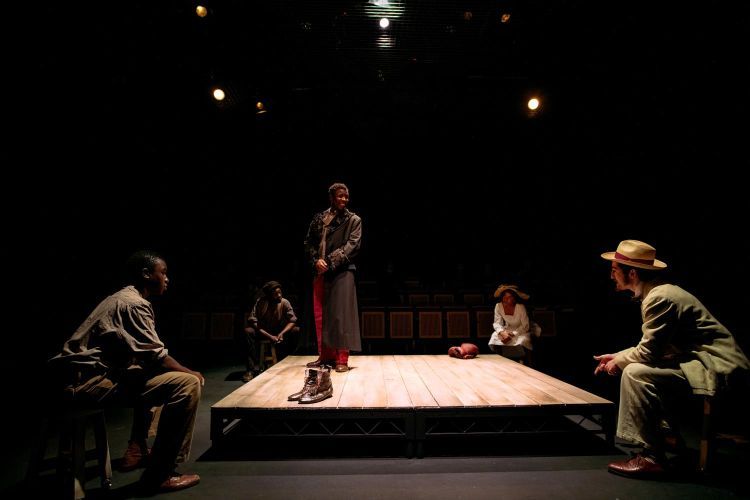 Actors sit at four corners of a square set of The Royale